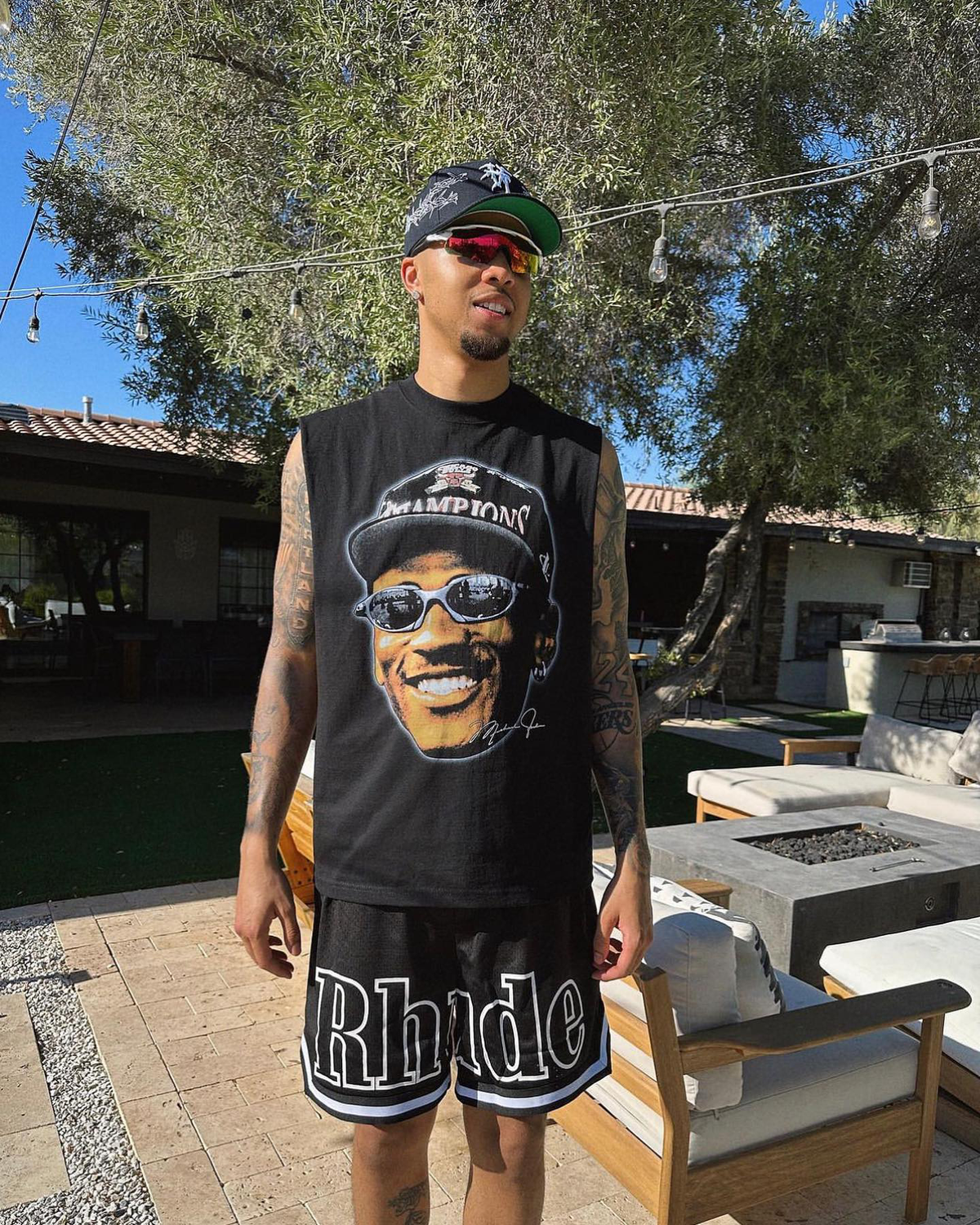 Drouq graphic tee styled outdoors with a black cap and sunglasses